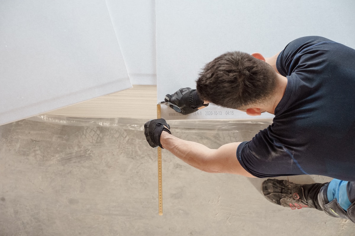 Carpenter measuring timber with a folding rule at a residential job site