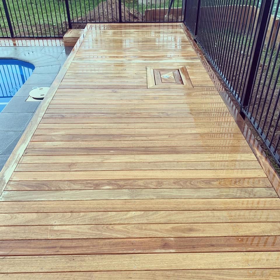 Oiled hardwood pool deck with safety fencing in Charlestown