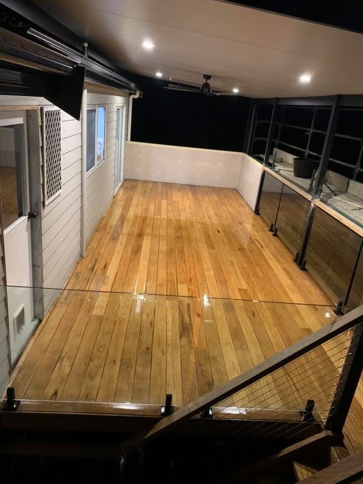 Elevated timber deck with glass balustrade illuminated at night